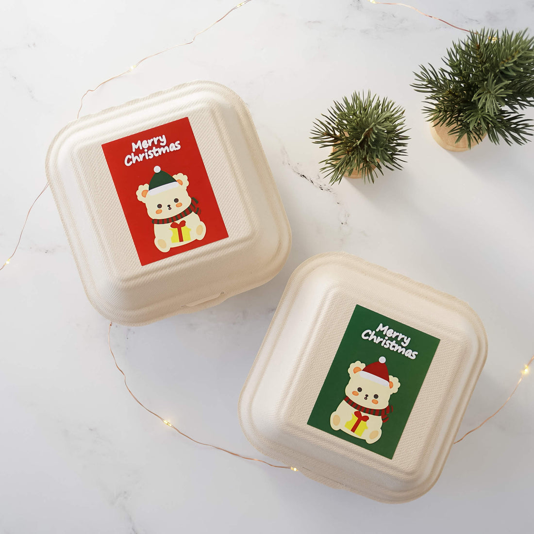 A roll of stickers with a bear design, featuring Christmas-themed accessories, placed on a white surface with decorative elements.