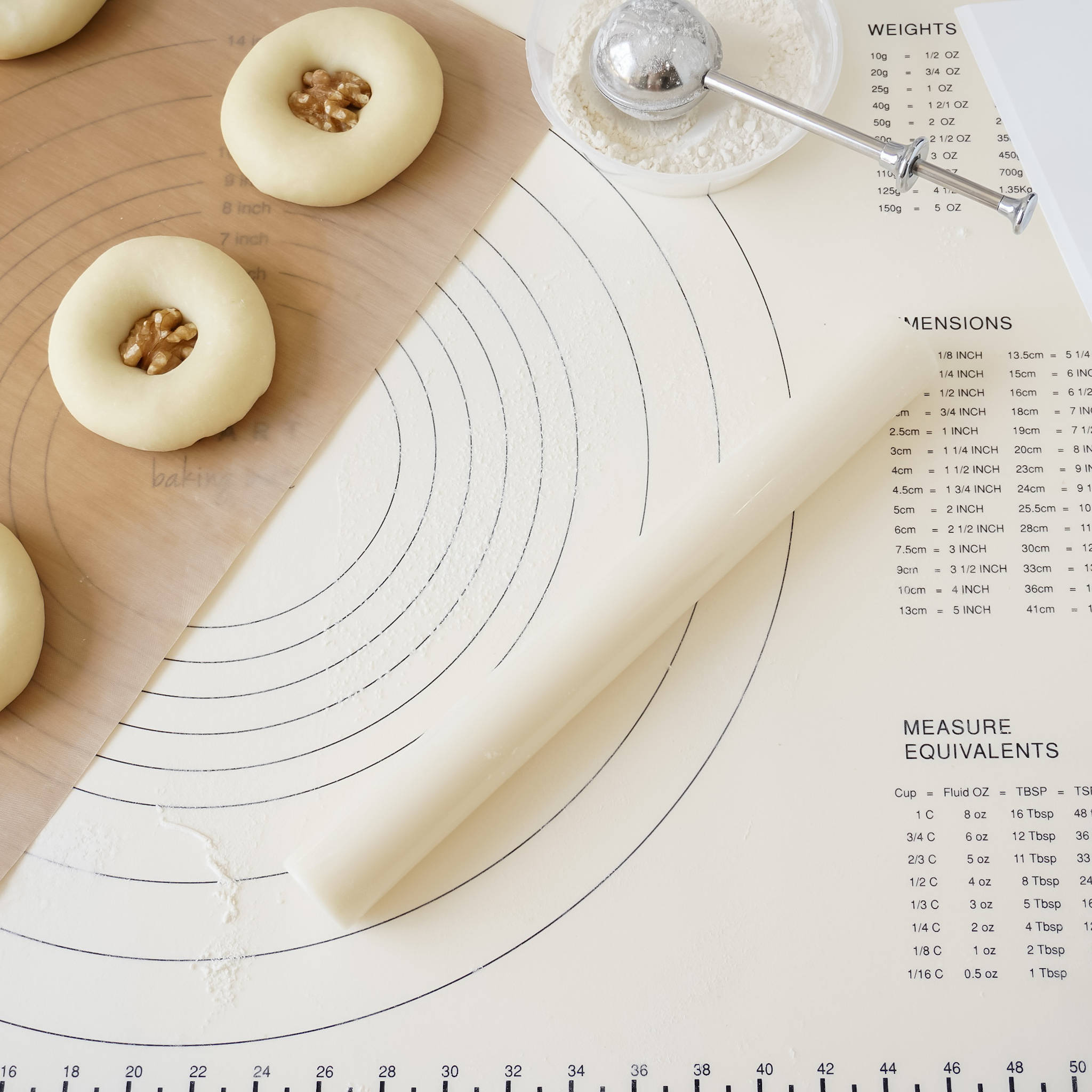 A beige rolling pin made of ABS plastic is laid out on a flat surface with a sheet of dough, showing the smooth, non-stick surface of the pin.