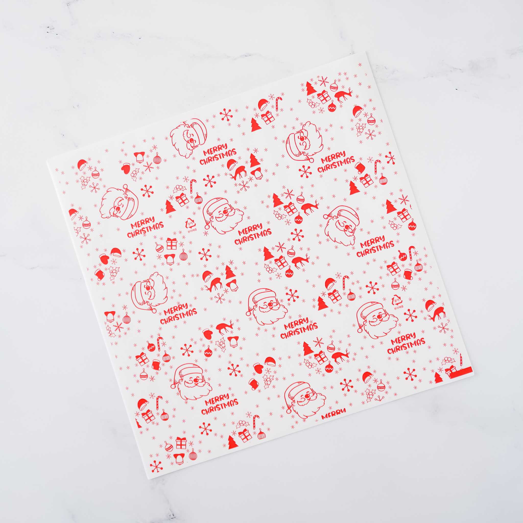 Red and white Christmas wrapping paper features a repeating pattern of Santa Claus illustrations and the phrase &