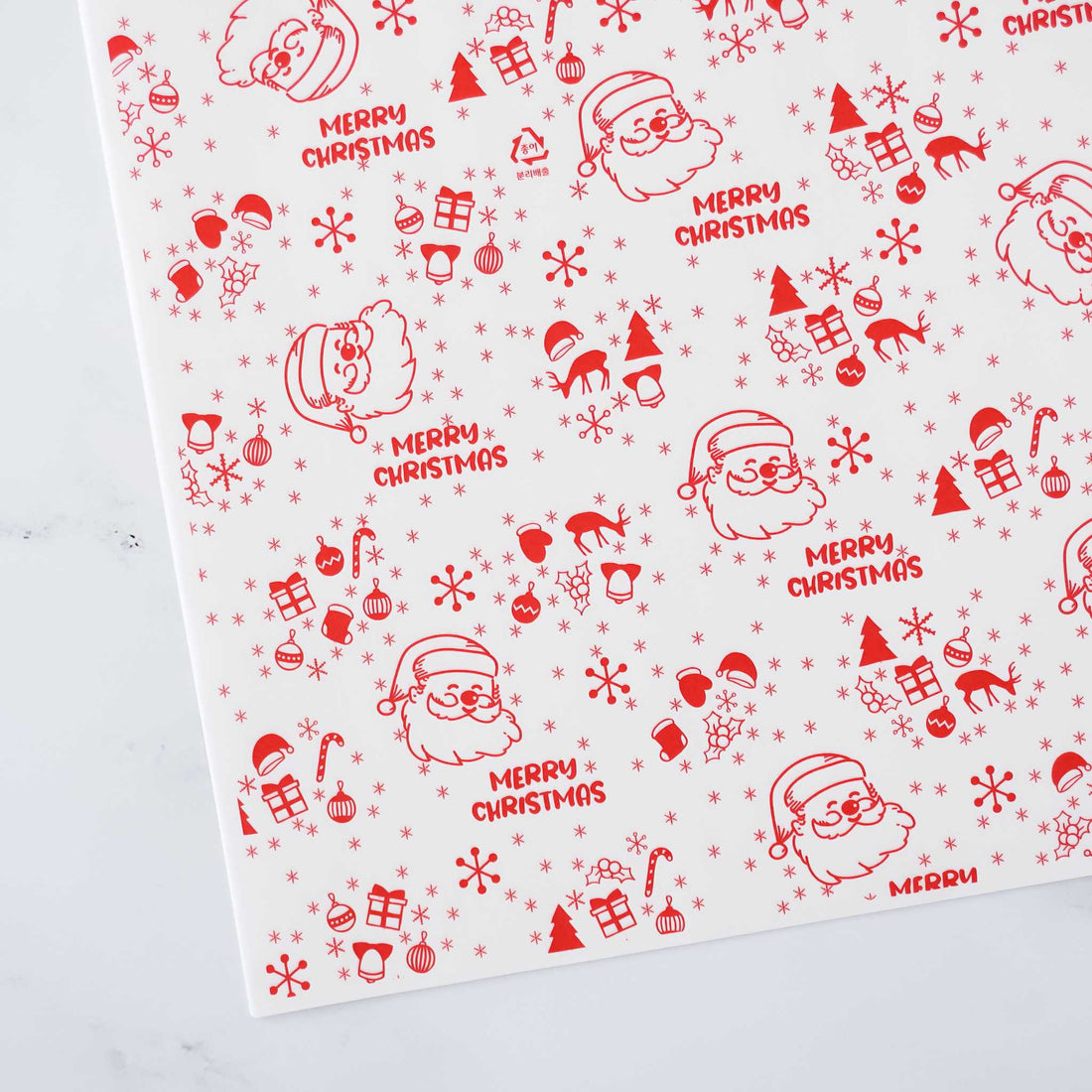 Red and white Christmas wrapping paper features a repeating pattern of Santa Claus illustrations, snowflakes, Christmas trees, candy canes, and gift boxes. The text &