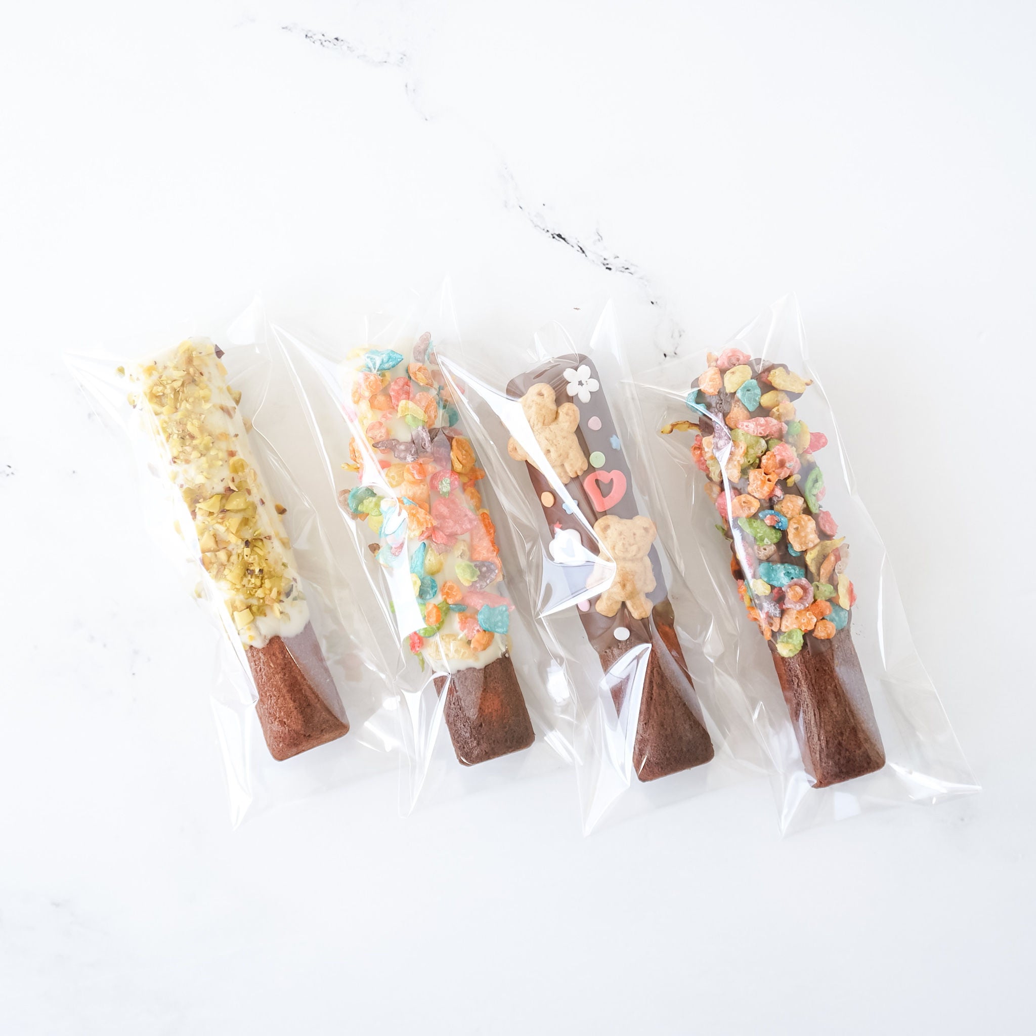 Four clear cellophane bags containing packaged food items, displayed on a white background.