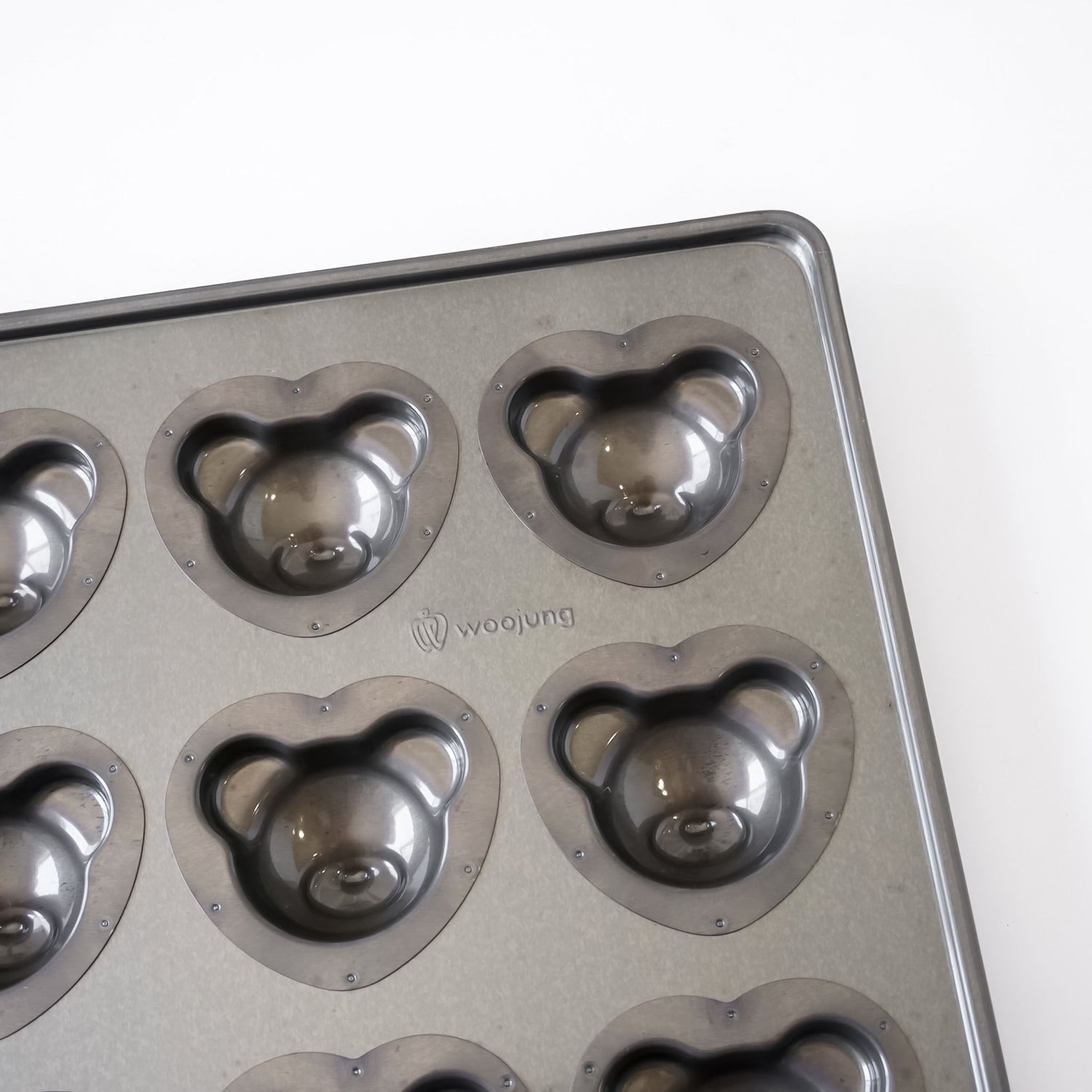 A gray metal bear-shaped mold tray with multiple bear-shaped cavities, photographed on a plain white background. The brand name &
