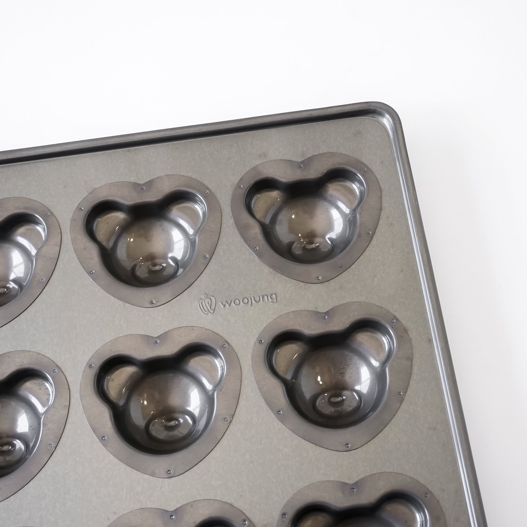 A gray metal bear-shaped mold tray with multiple bear-shaped cavities, photographed on a plain white background. The brand name &