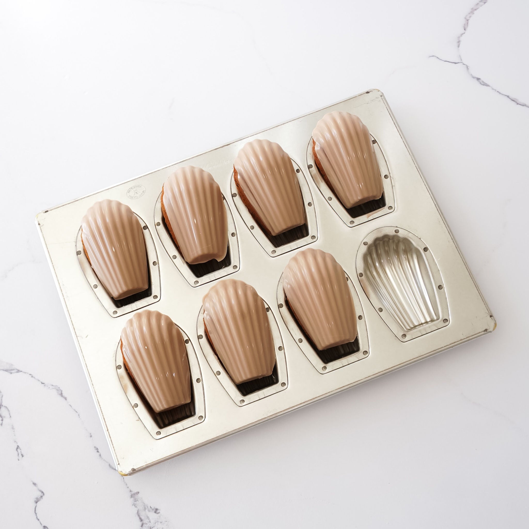 silicone coated deep madeleine mold on a marble surface