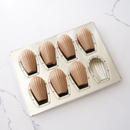 silicone coated deep madeleine mold on a marble surface