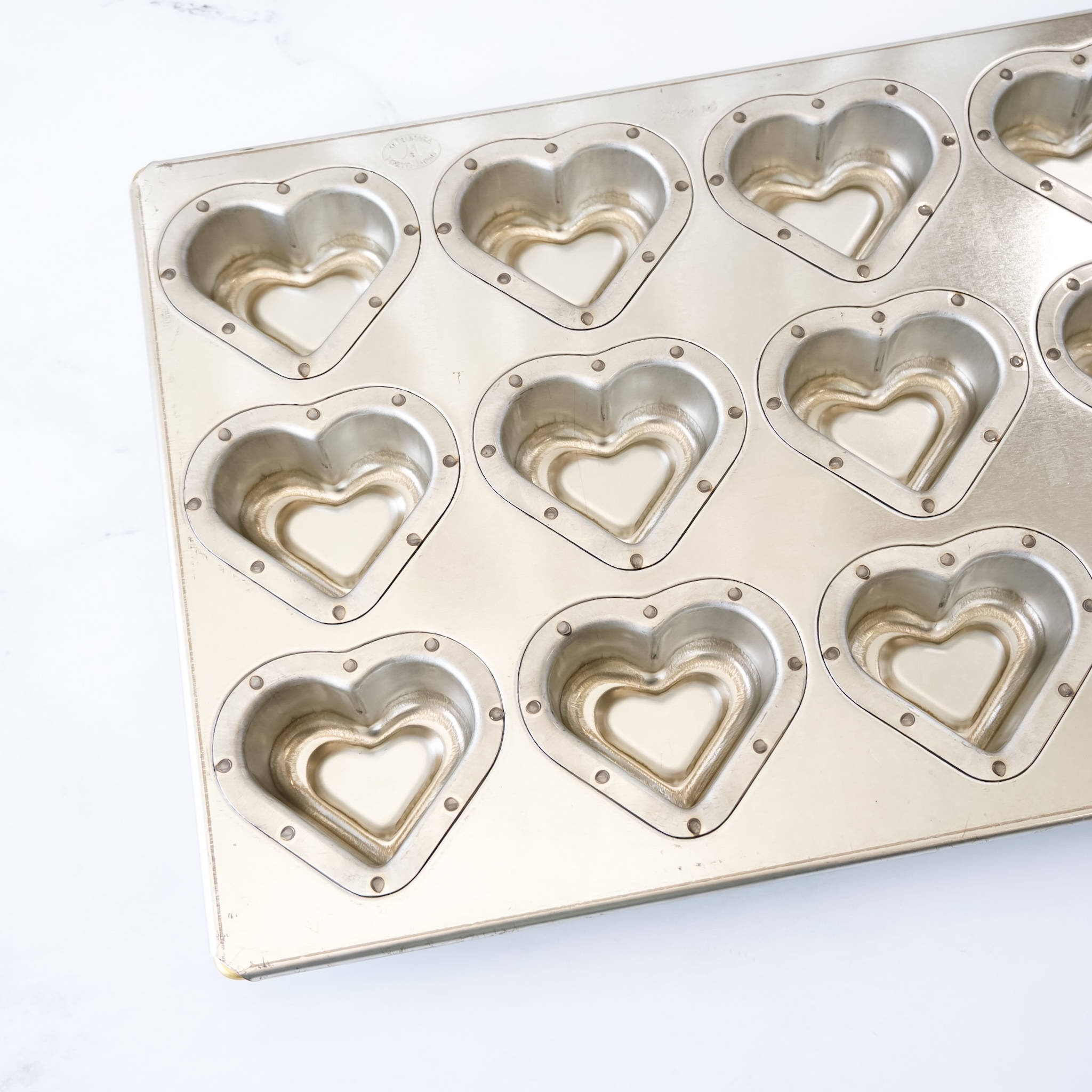 Metal heart-shaped baking mold on a white background