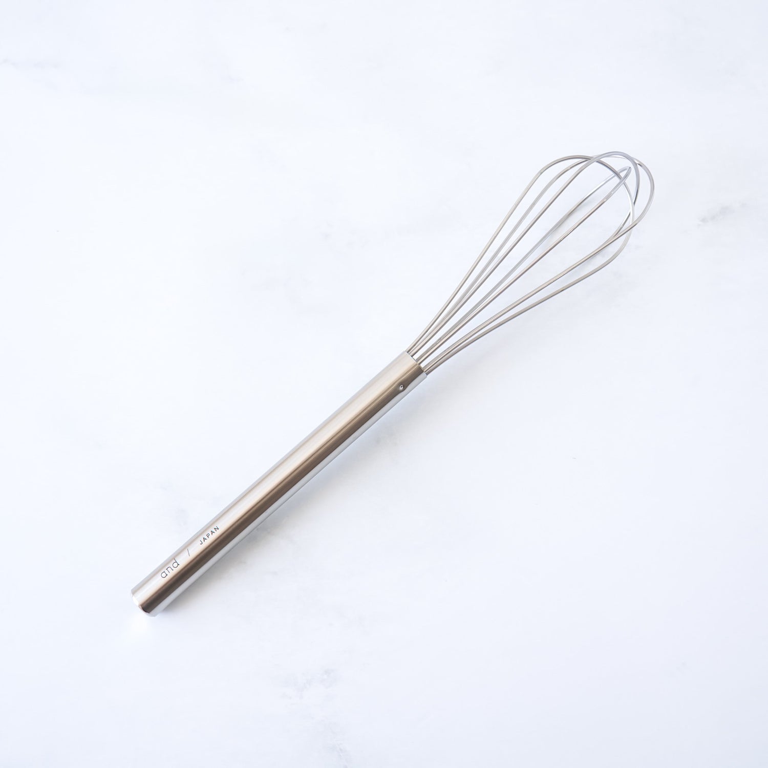 stainless steel mini whisk on a white background