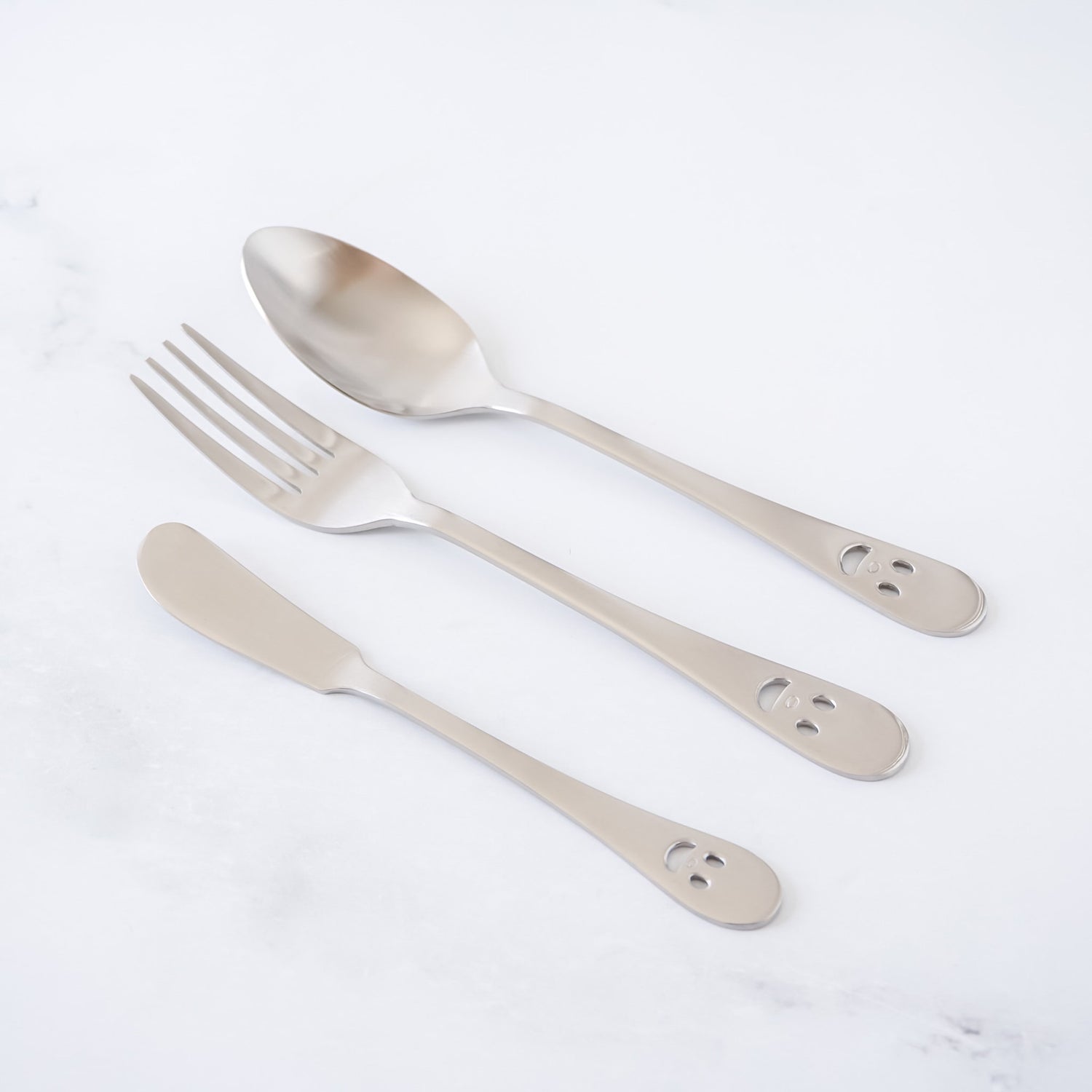 Set of silver cutlery including a spoon, fork, and knife on a white background
