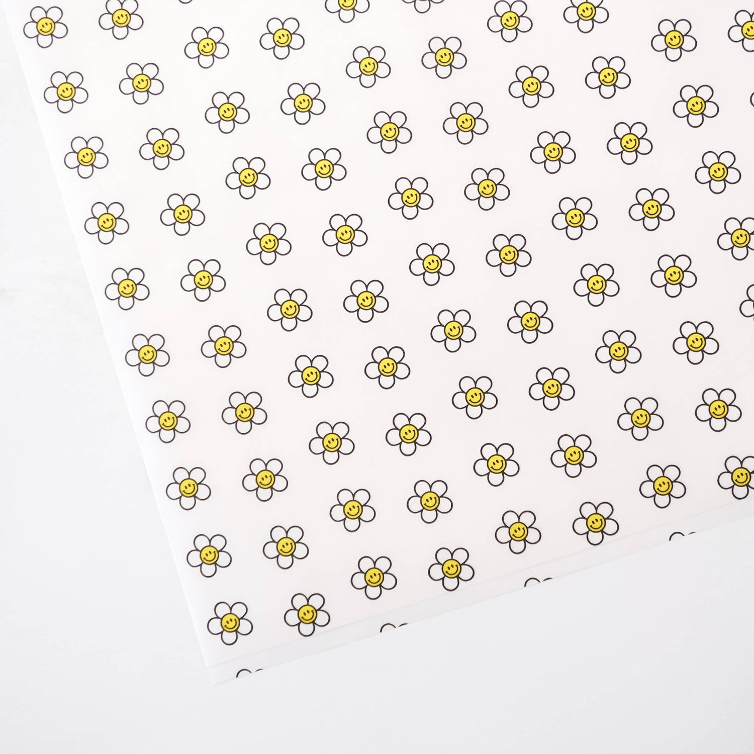Pattern of smiley daisy flowers with yellow centers on a white background