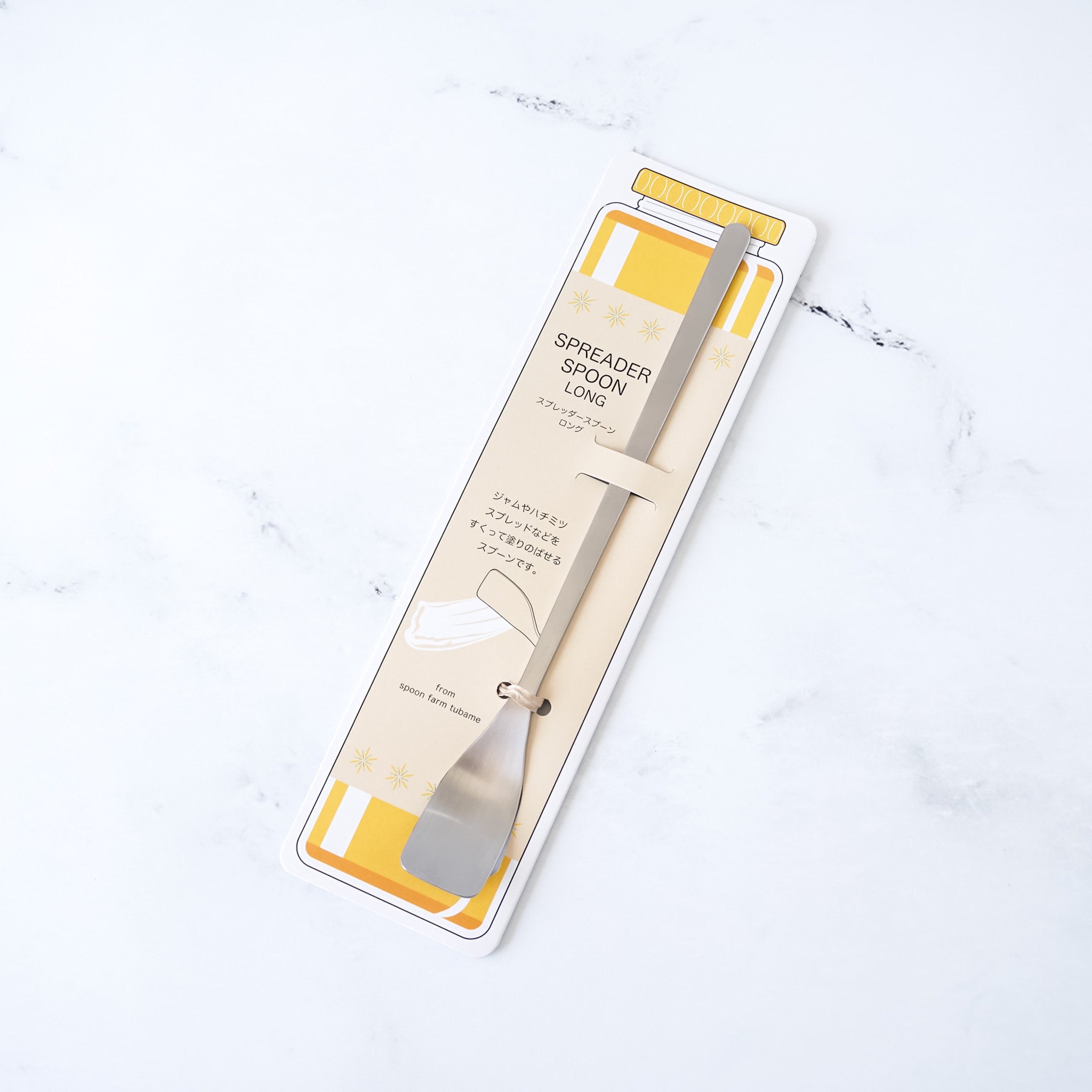 Spreader spoon in packaging on a light background