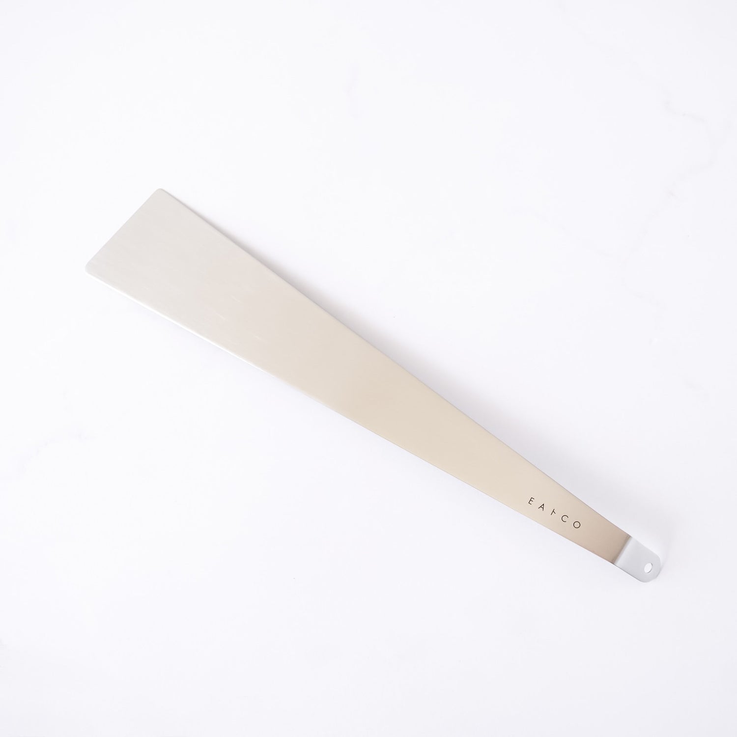 Stainless steel spatula with a metallic handle on a white background