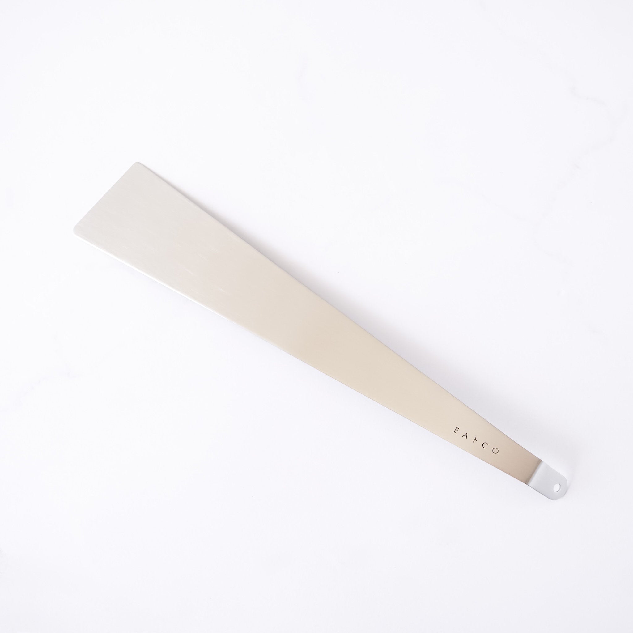 Stainless steel spatula with a metallic handle on a white background