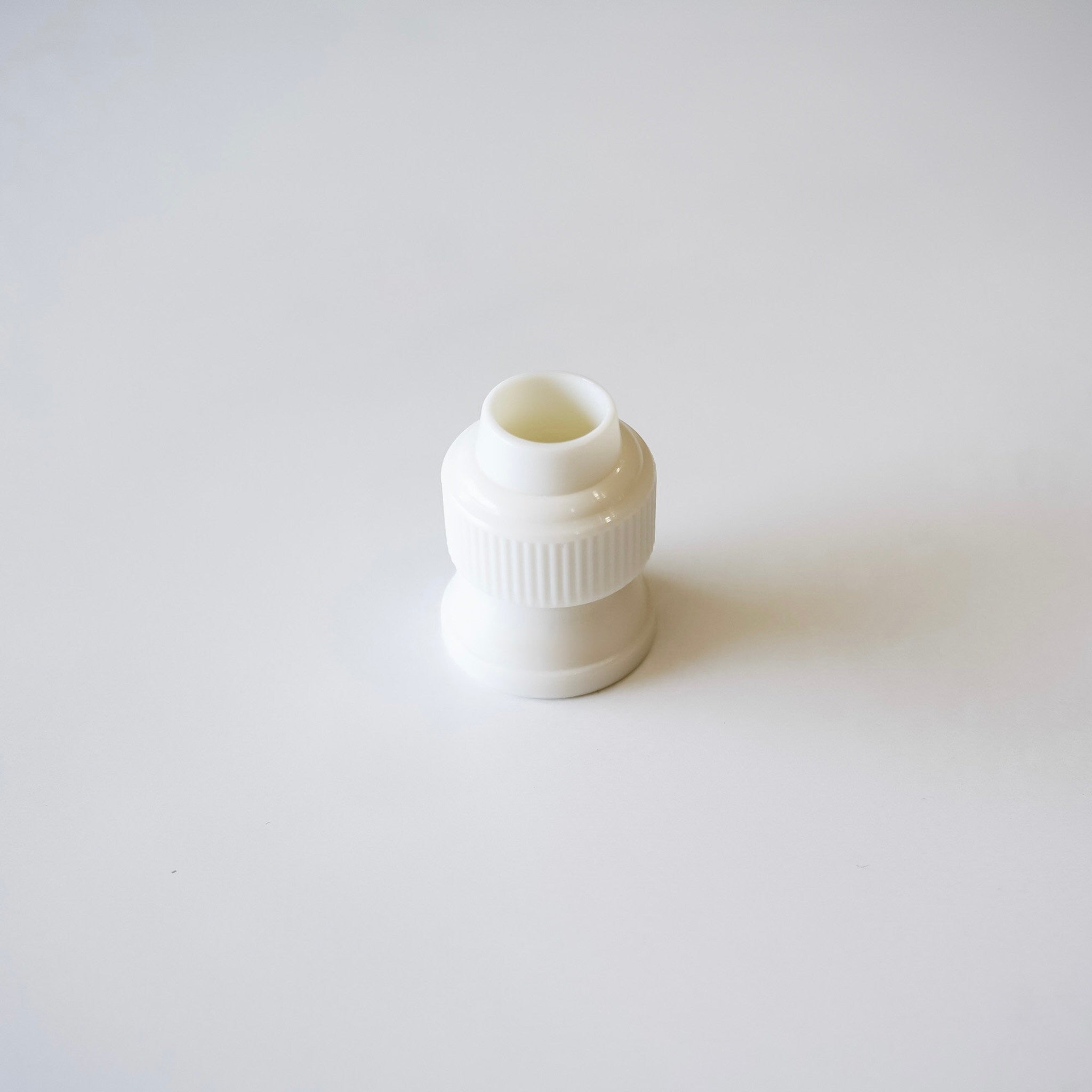 White plastic coupler on a light gray background
