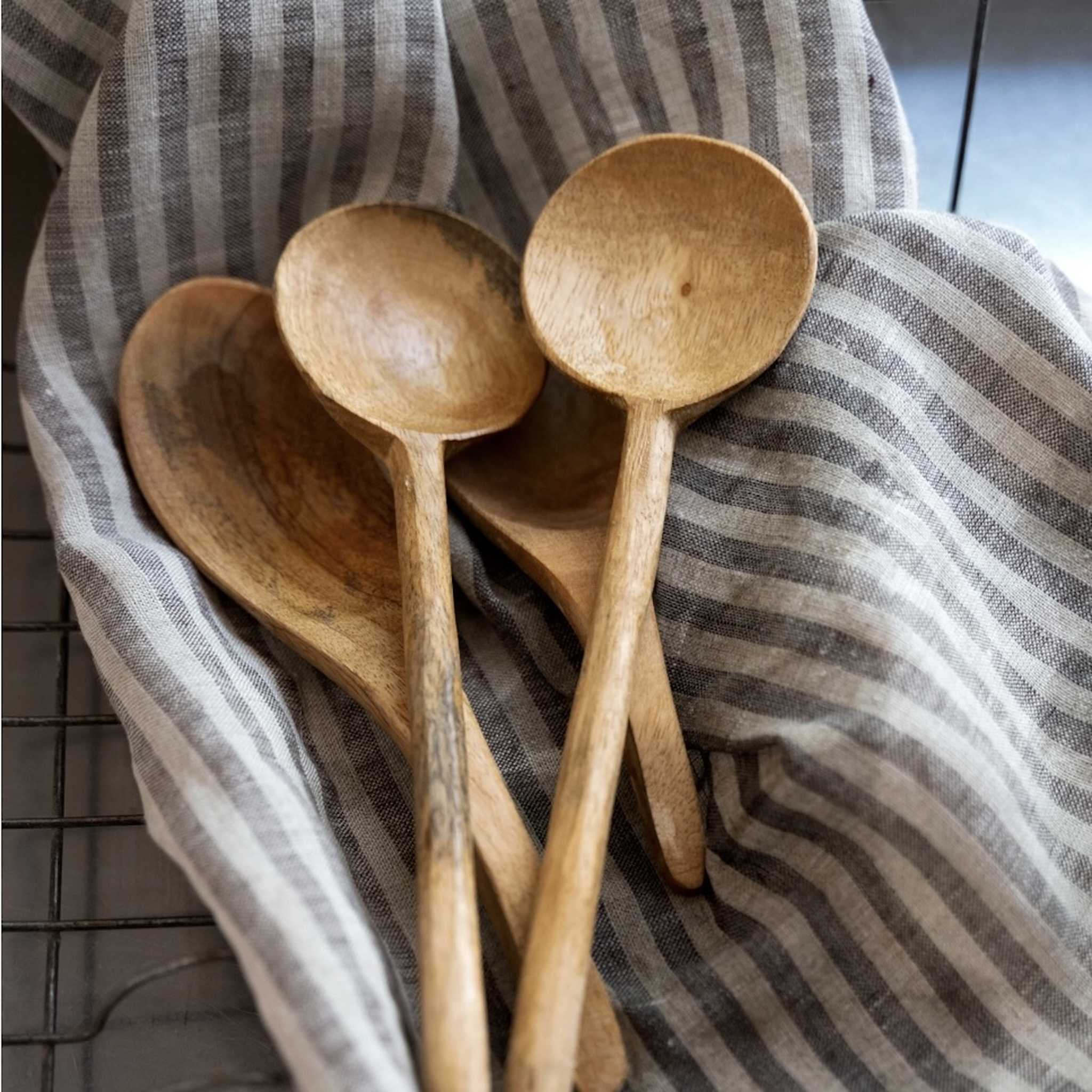 Set of wooden spoons on a striped fabric background