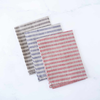 Three striped towels in gray, blue, and red on a white background