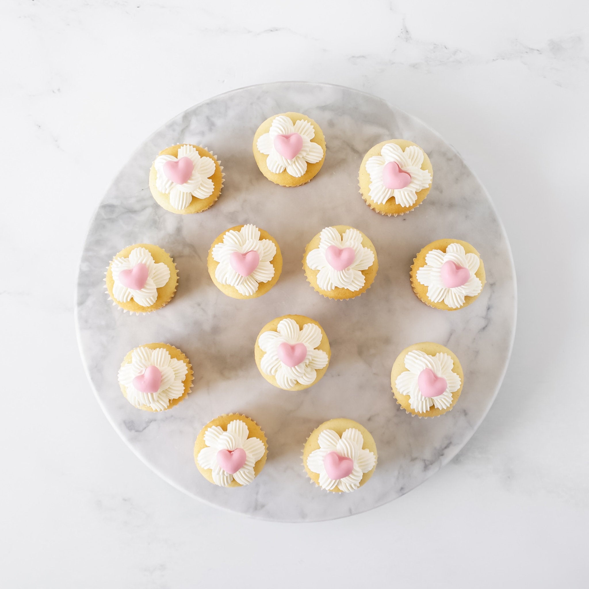 Decorative cupcakes on a marble board with a white background