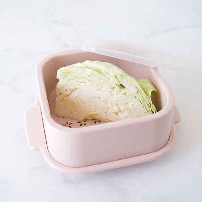 Pink plastic container with a head of cabbage inside on a white background