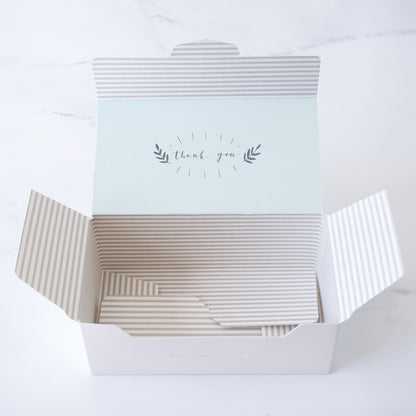 Open gift box with a light blue top inside that says &