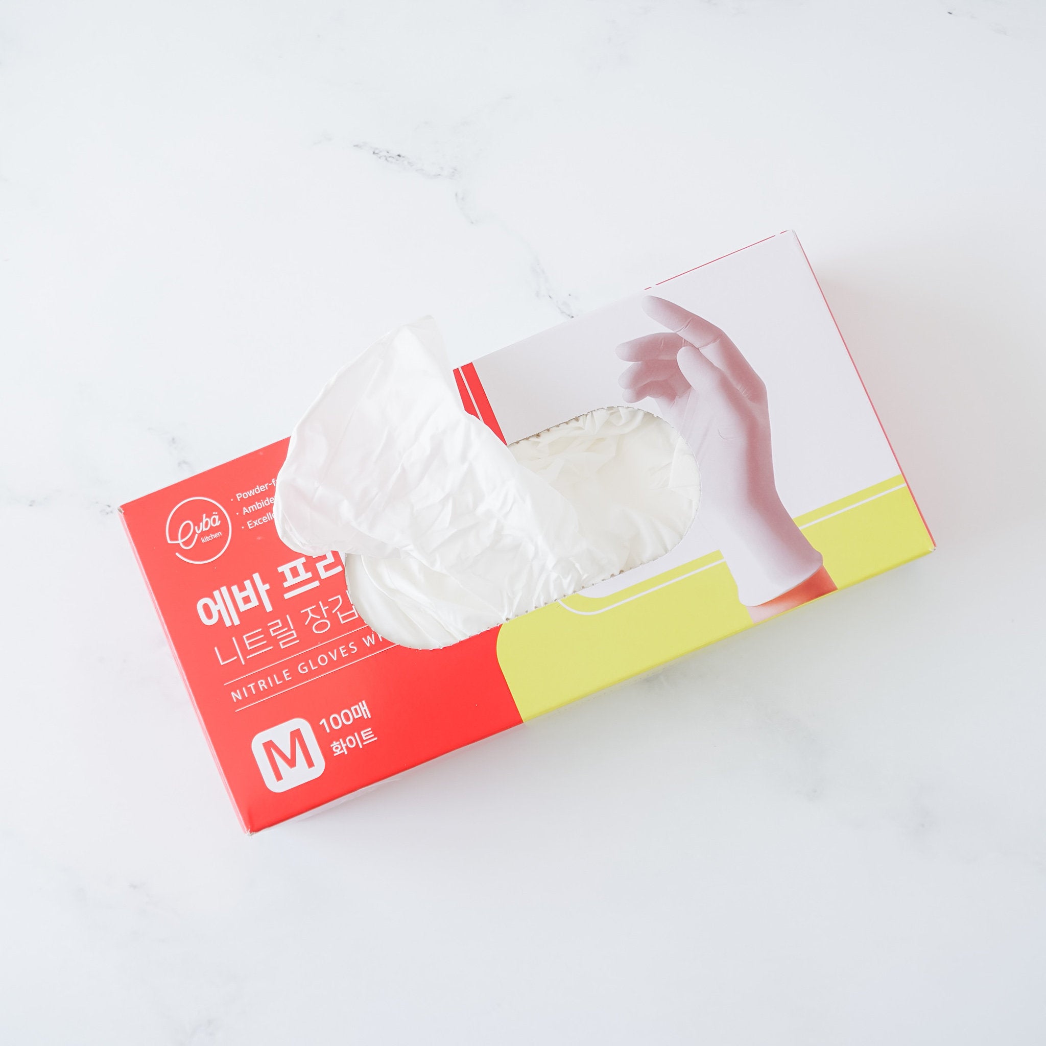 A pack of white nitrile gloves in a red and yellow box, with text indicating the product is powder-free, food safe, and has textured fingertips.