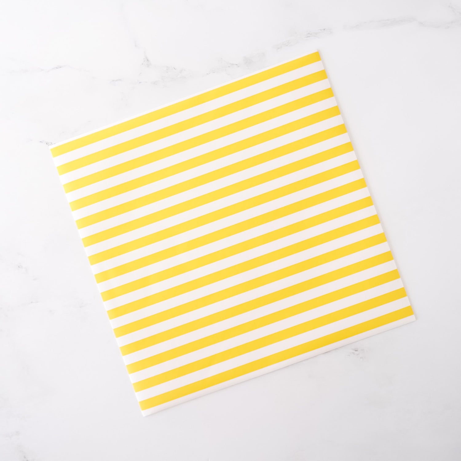 Yellow and white striped deli paper on a white background