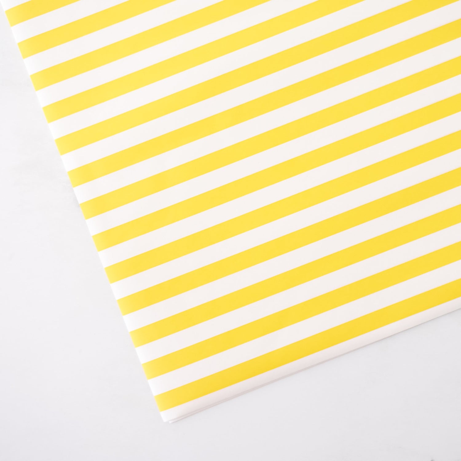 Yellow and white striped paper on a light gray background